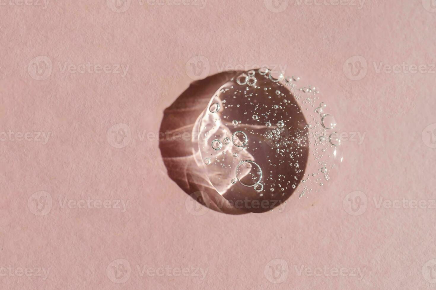 Transparent cosmetic gel on a pink background. photo