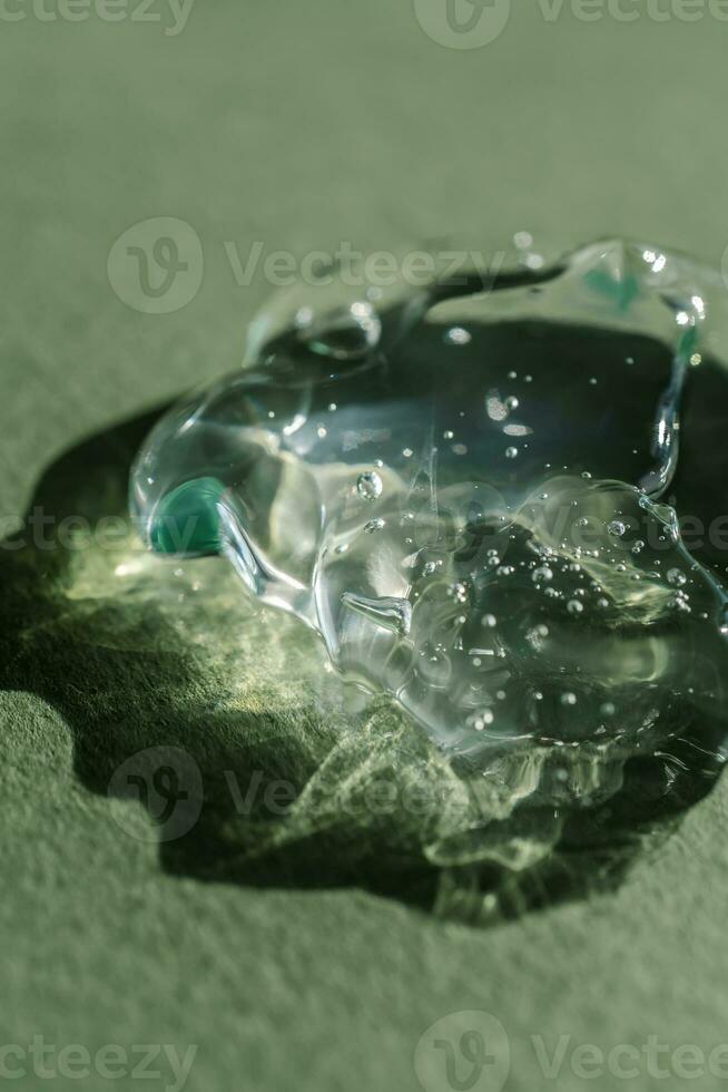 Transparent cosmetic gel on a green background. photo