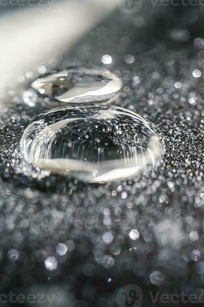 A drop of cosmetic gel on a black shining background. photo