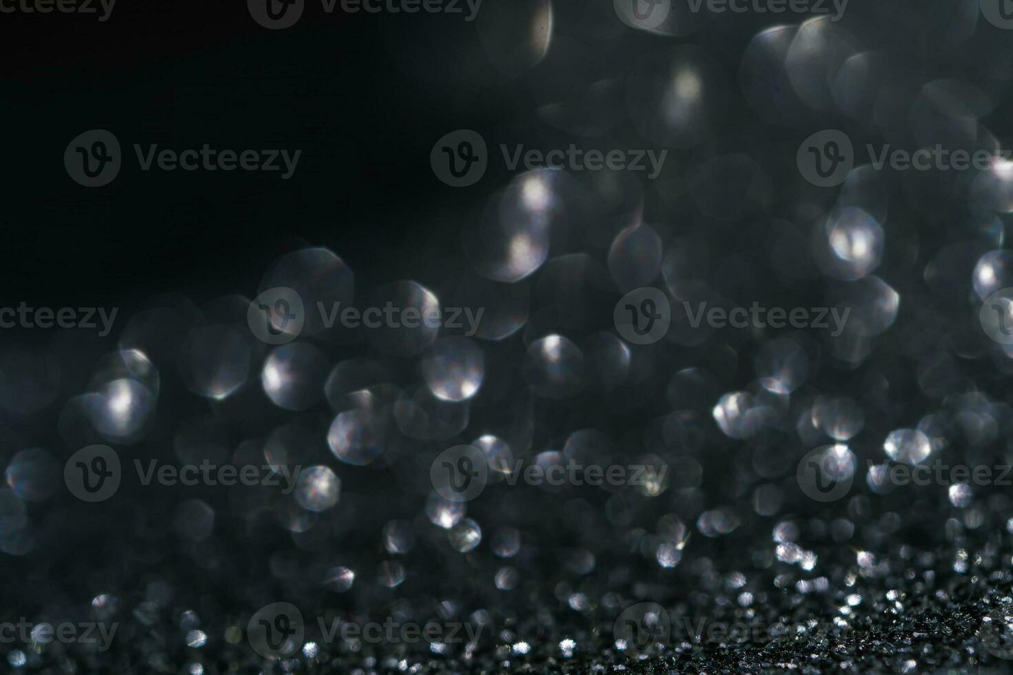 Black abstract glitter background with shiny bokeh photo