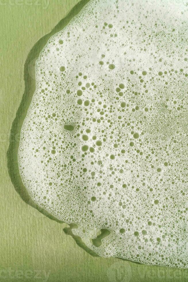 Texture of white foam on a green background. photo