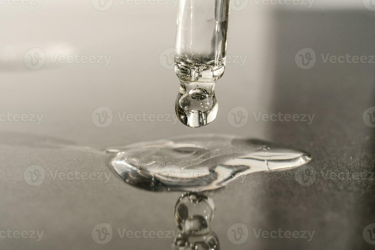 The texture of serum or oil with a pipette on a grey background. photo