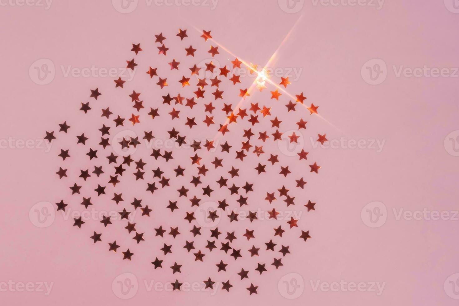 Abstract pink background with sparkles in the shape of stars. photo