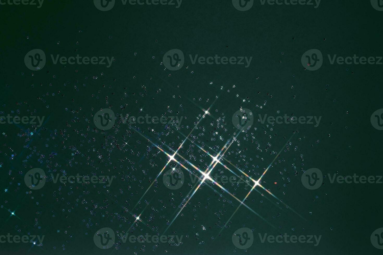 Abstract green background with sparkles in the shape of stars. photo