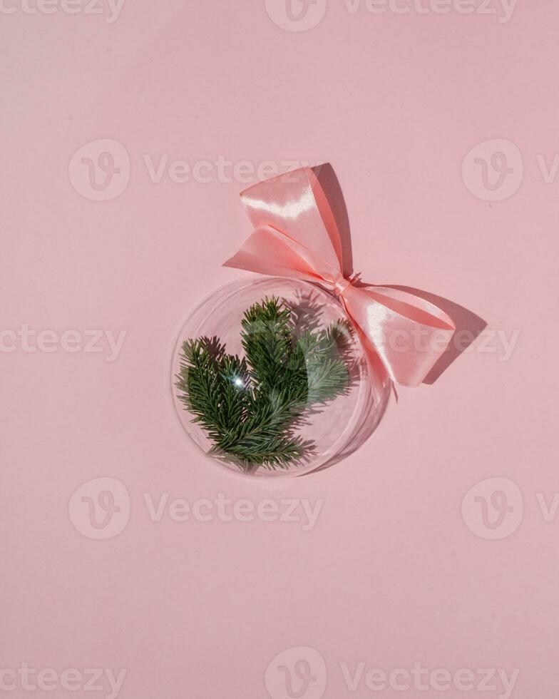 A balloon with a Christmas branch on a pink background. photo