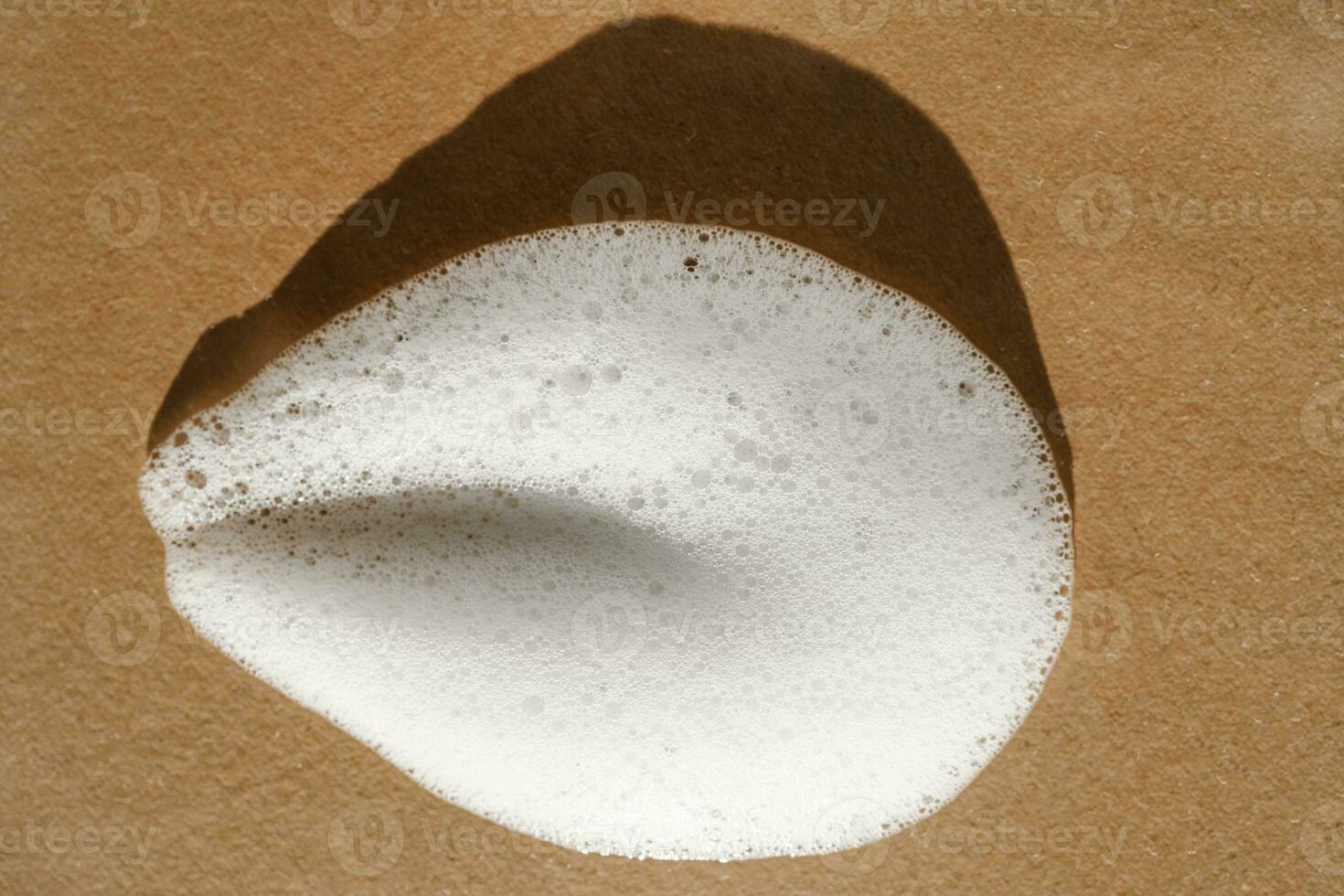 Texture of white foam on a beige background. photo