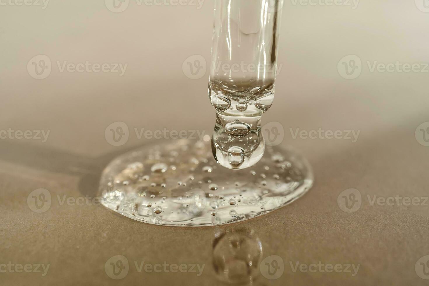 The texture of serum or oil with a pipette on a beige background. photo