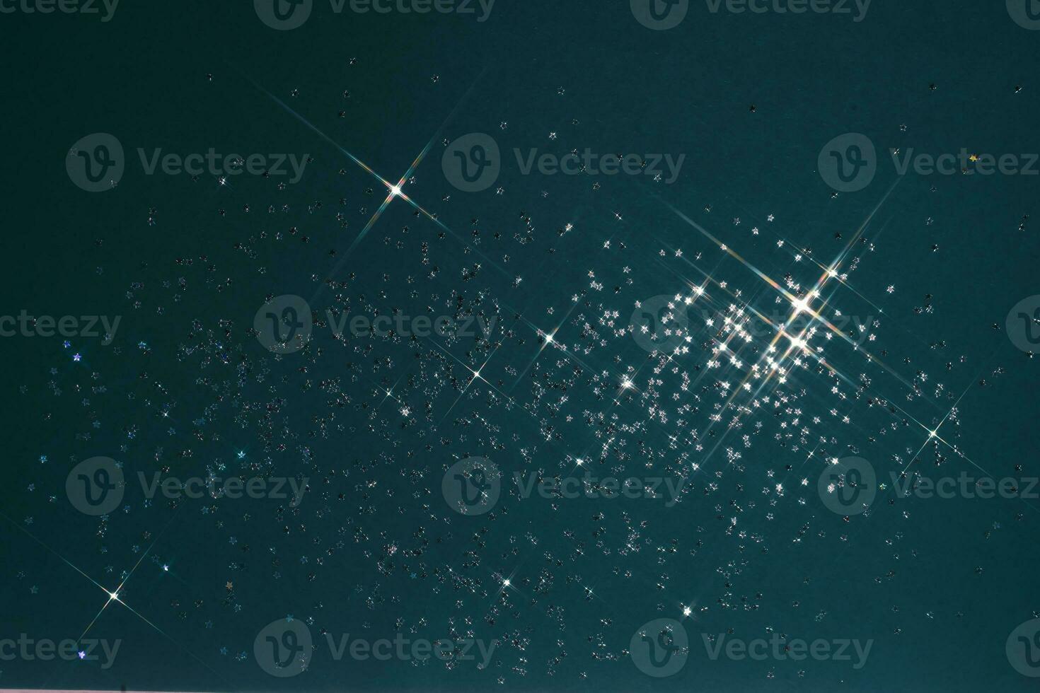 Abstract deep blue background with sparkles in the shape of stars. photo