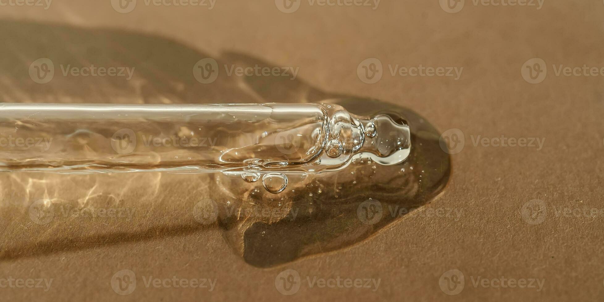 The texture of serum or oil with a pipette on a beige background. photo