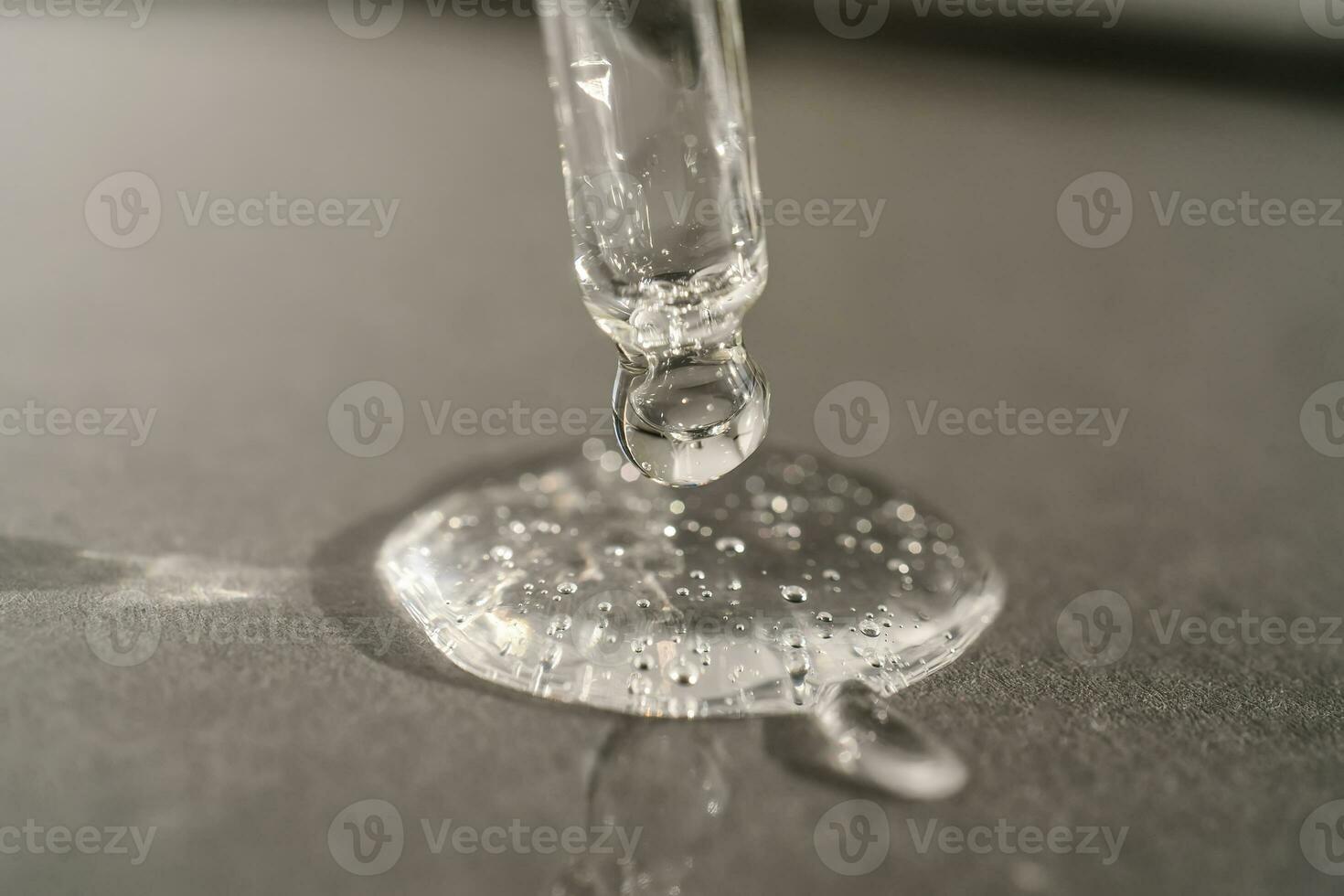 The texture of serum or oil with a pipette on a grey background. photo