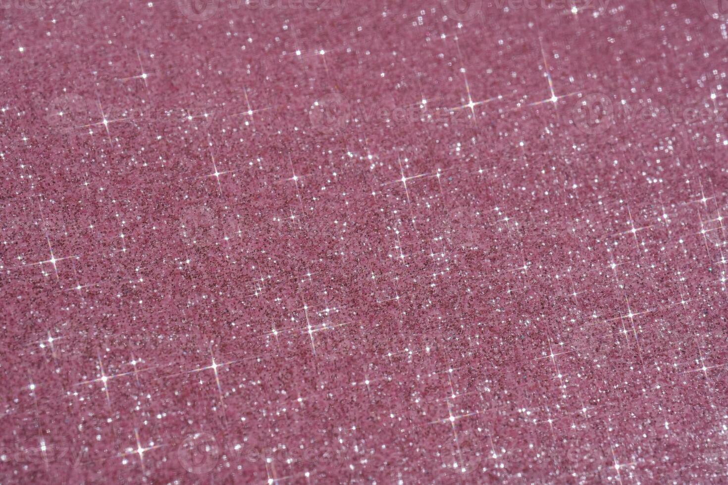 Abstract pink background with sparkles in the shape of stars. photo
