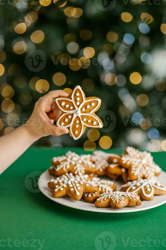 Ginger Christmas cookies in children's hands on the background of the Christmas tree. photo