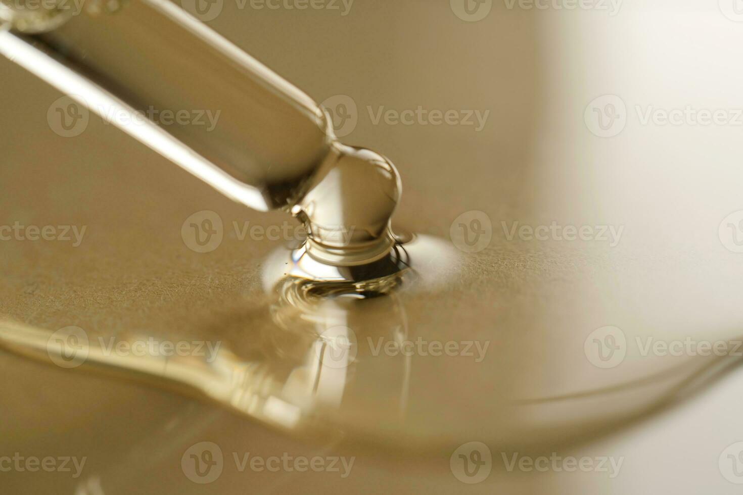 Pipettes with oil or serum on a golden background. photo