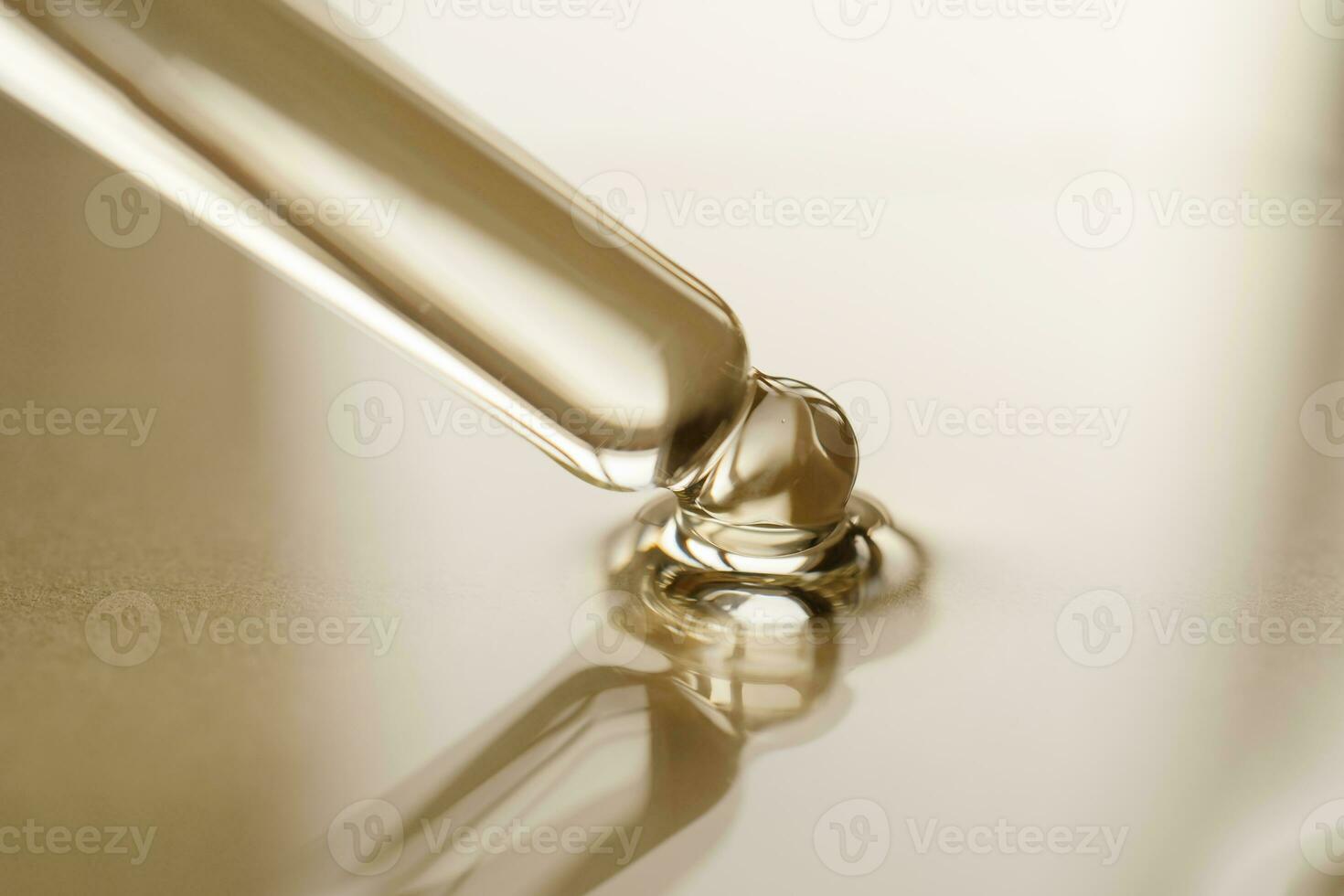 Pipettes with oil or serum on a golden background. photo