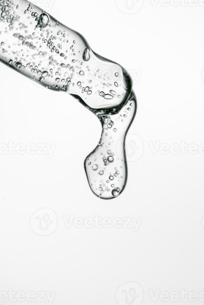 Transparent pipette with cosmetics on a light background. photo