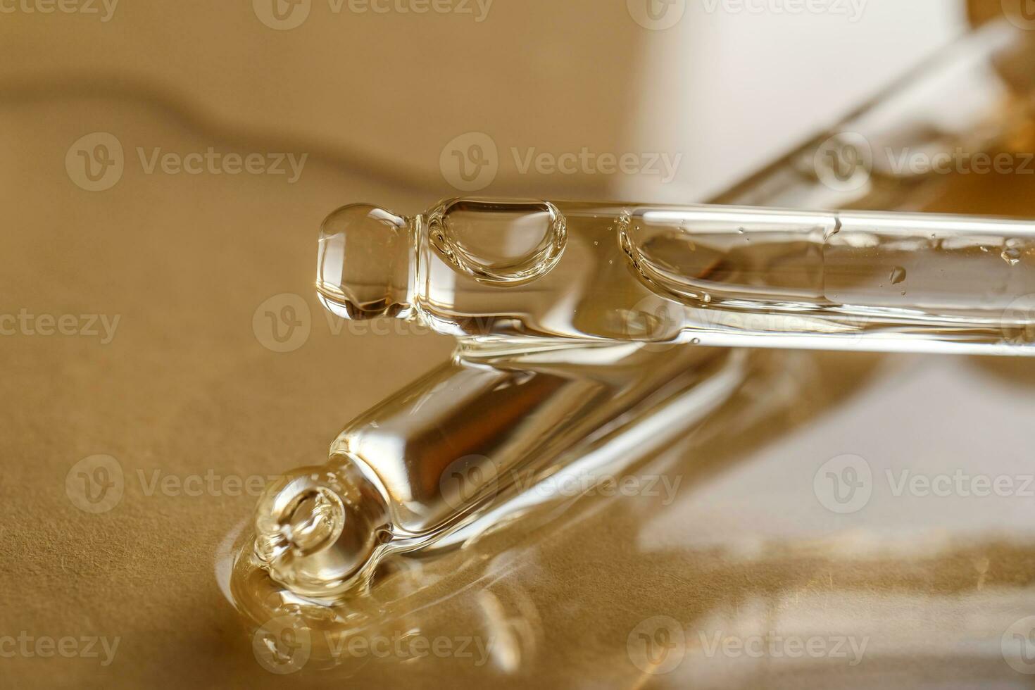 Pipettes with oil or serum on a golden background. photo