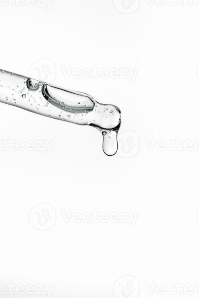 Transparent pipette with cosmetics on a white isolated background. photo