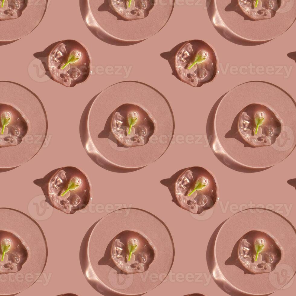 A drop of cosmetic gel with a flower on a pink background. photo
