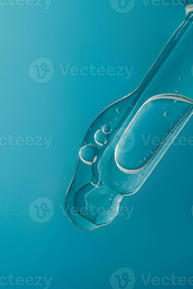 Pipette with cosmetic product in water with bubbles. photo