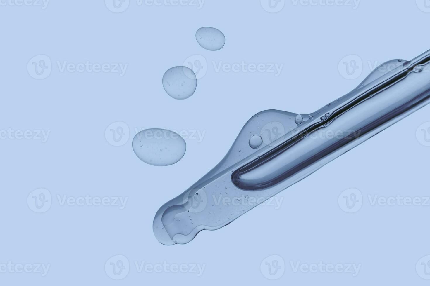 Pipette with cosmetic product in water with bubbles. photo