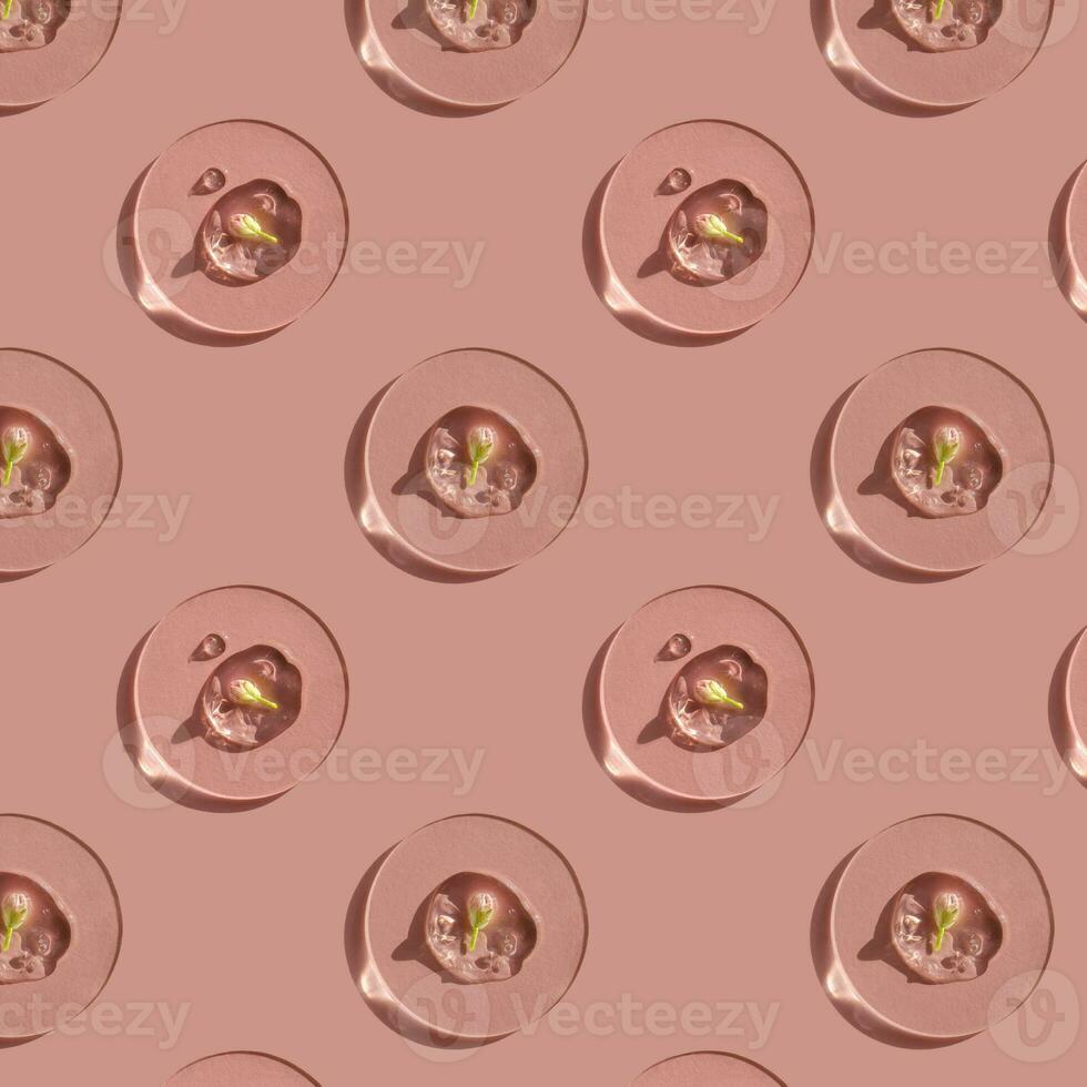 A drop of cosmetic gel with a flower on a pink background. photo