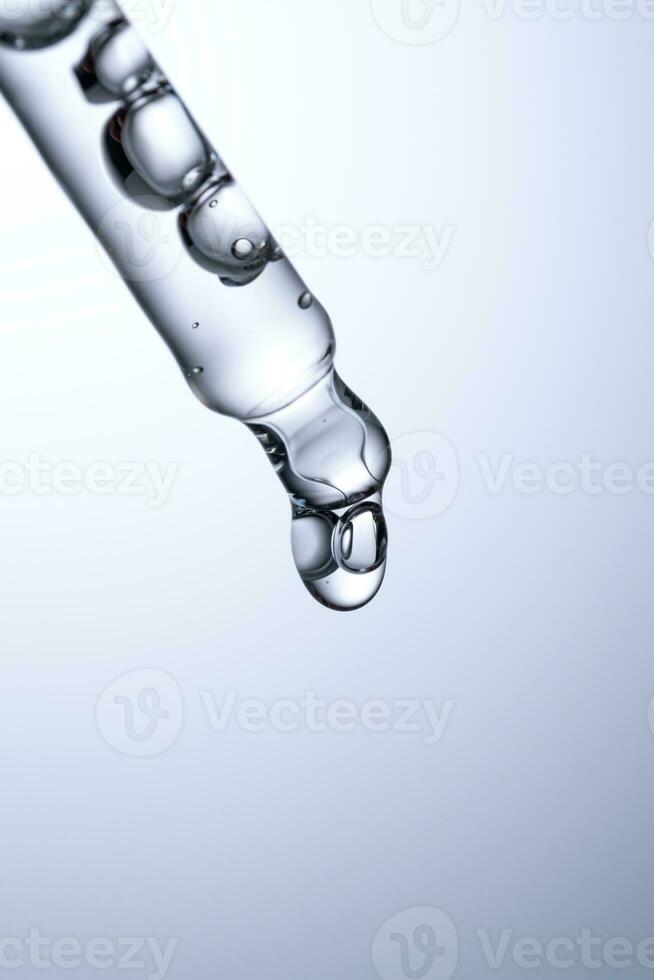 Pipette with serum or other cosmetic product on a blue background. photo