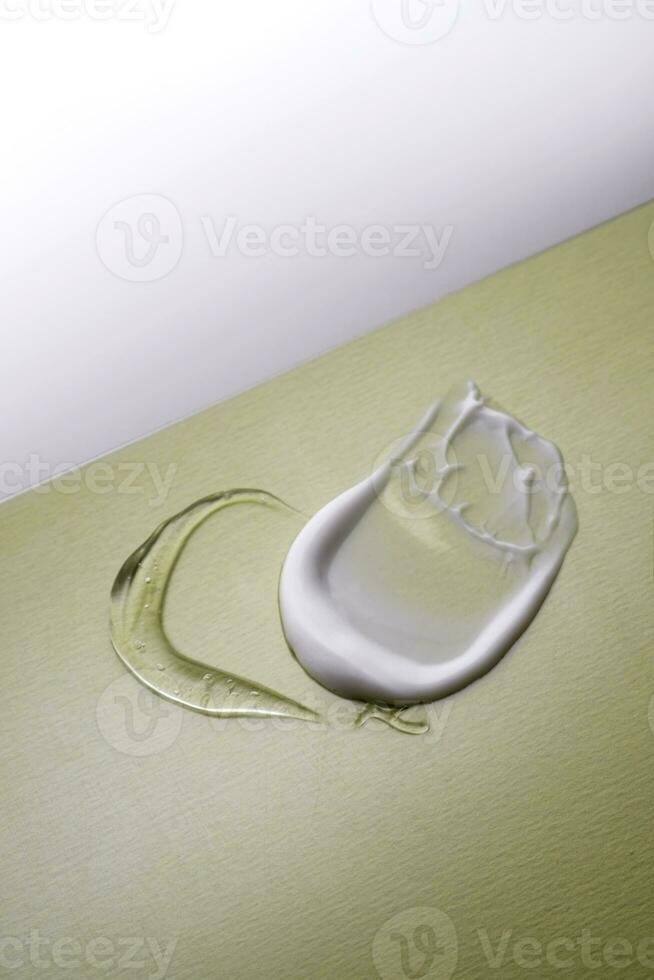 Serum and cream on a green background. Textures. photo