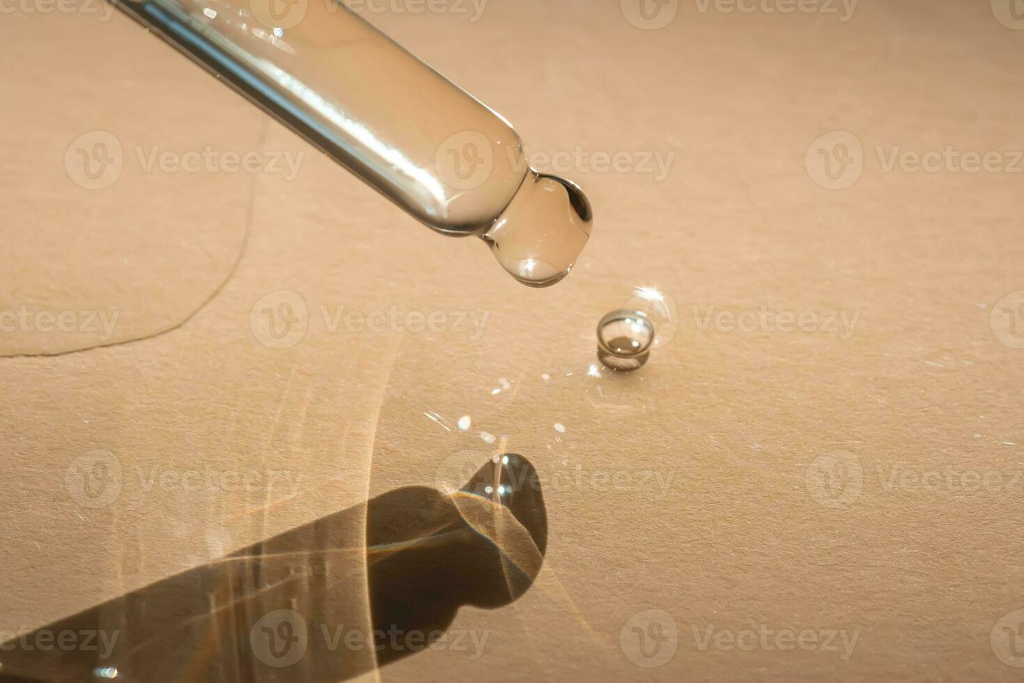 A pipette of cosmetic gel on a beige background. photo