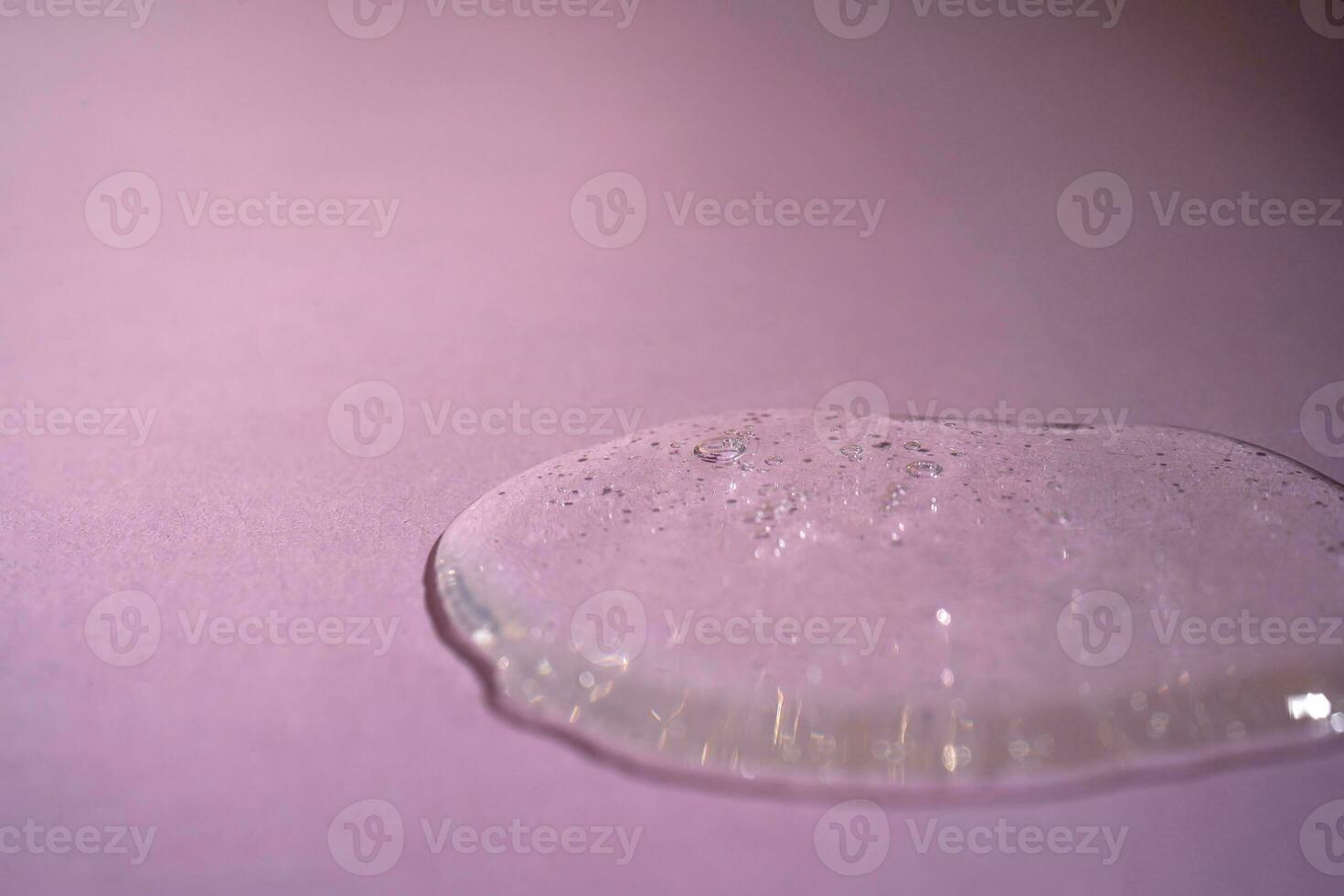 A drop of serum with bubbles on a beige background. photo