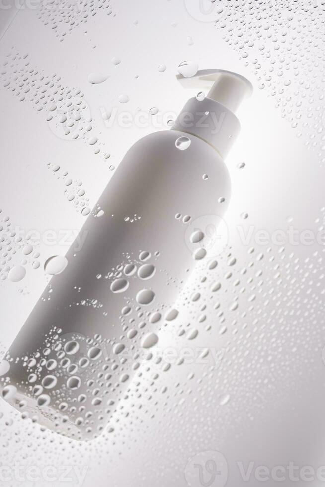 un botella de ducha gel, champú o cuerpo crema en el antecedentes de gotas. foto