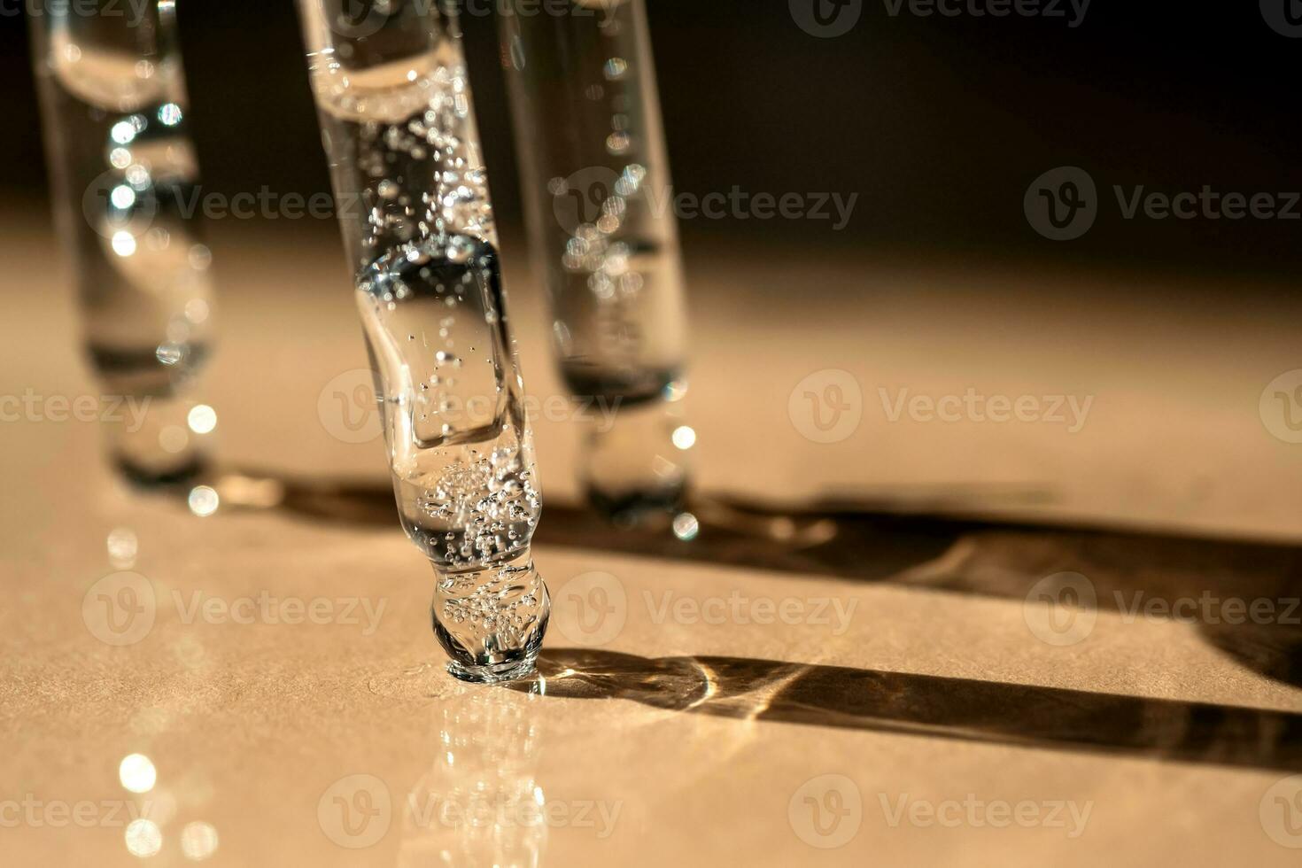 Tres pipetas de cosmético gel en un beige antecedentes. foto