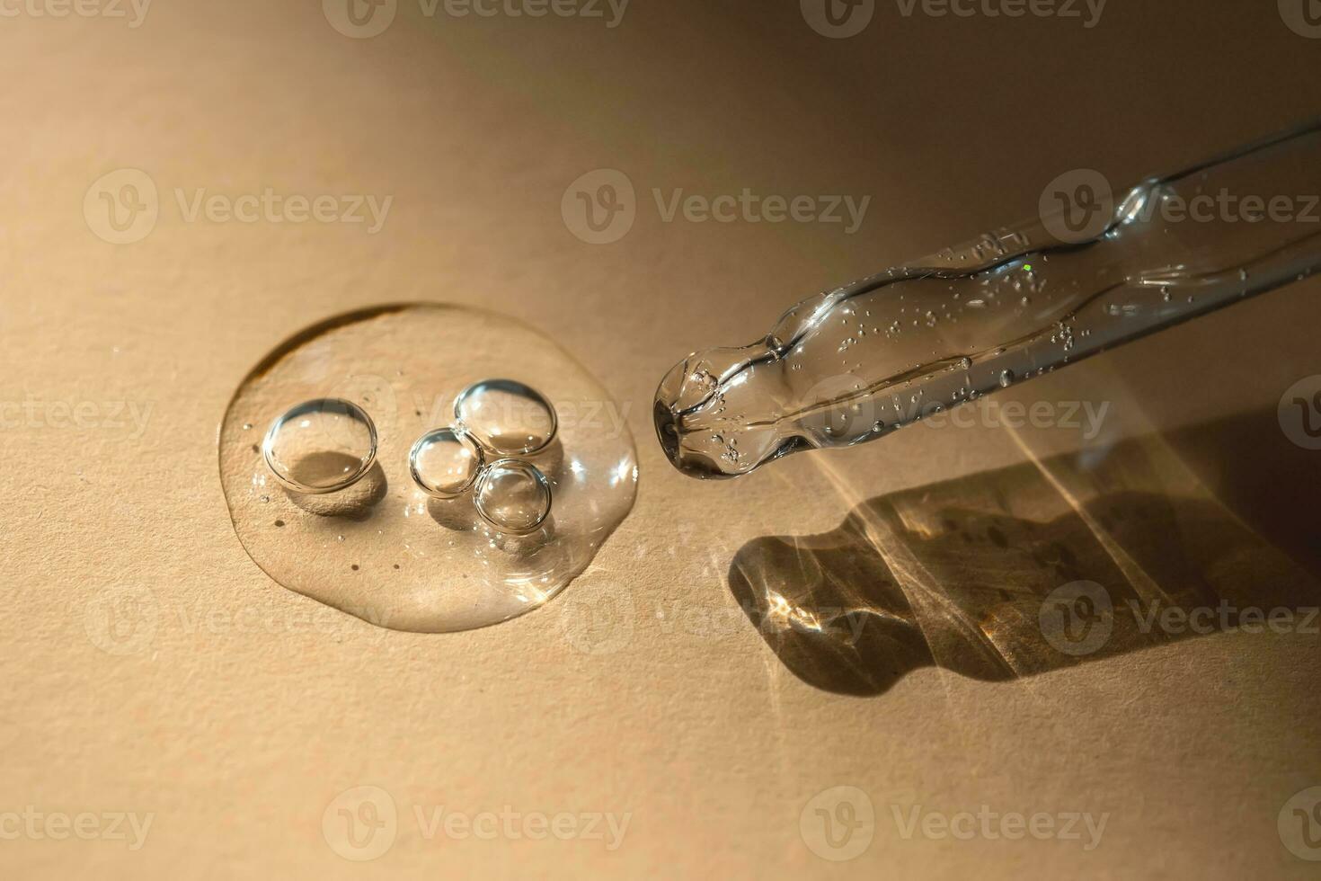 A pipette of cosmetic gel on a beige background. photo