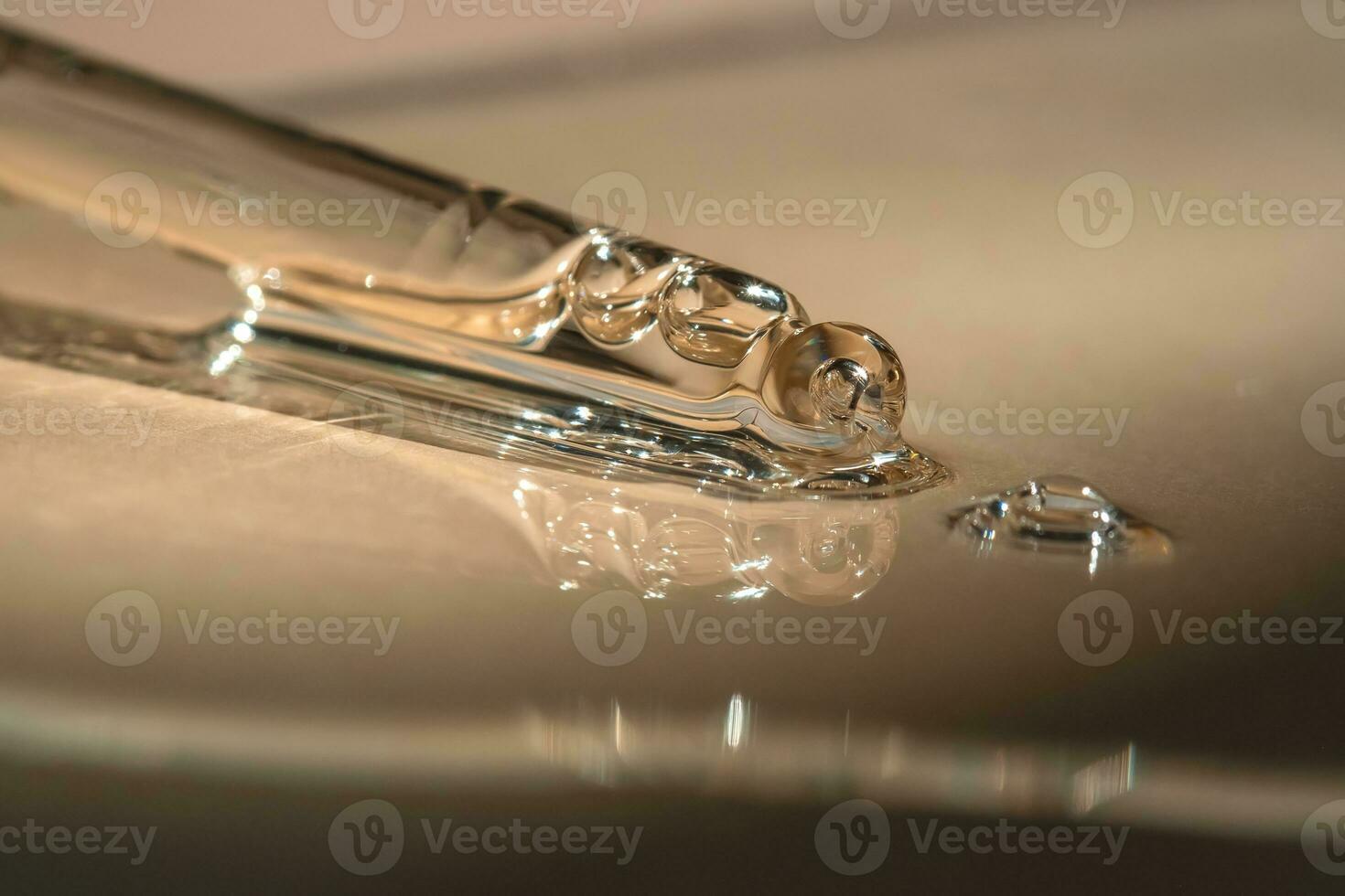 A pipette of cosmetic gel on a beige background. photo