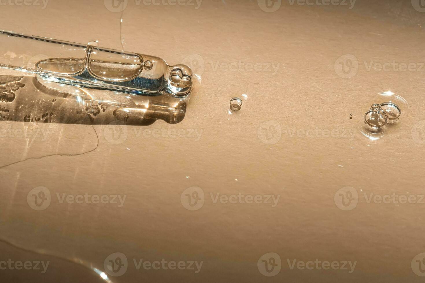 A pipette of cosmetic gel on a beige background. photo