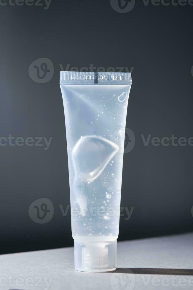 Transparent bottle of cosmetic gel on a dark background. photo