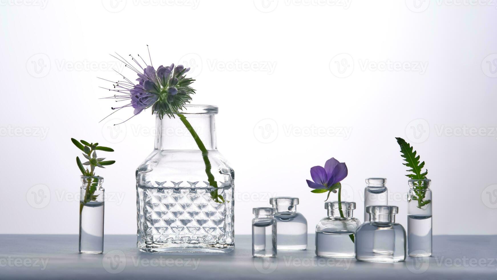 Different bottles of water with flowers on a light background. It can fit the theme of cosmetics, glass and freshness. photo