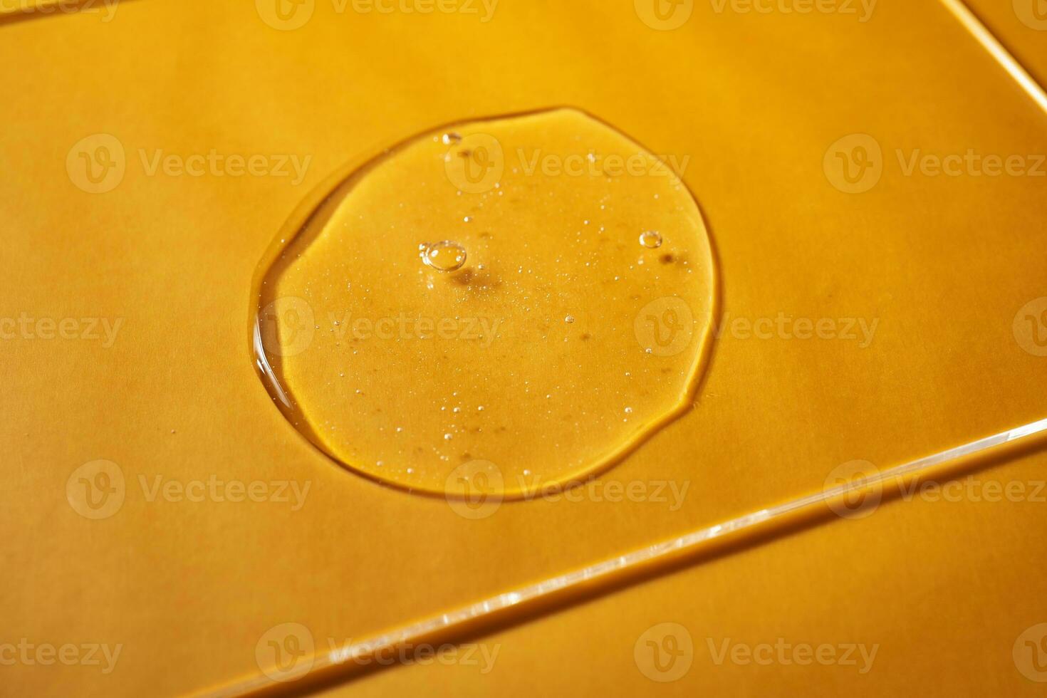 A drop of body gel or shampoo on a yellow saturated background. Texture. photo