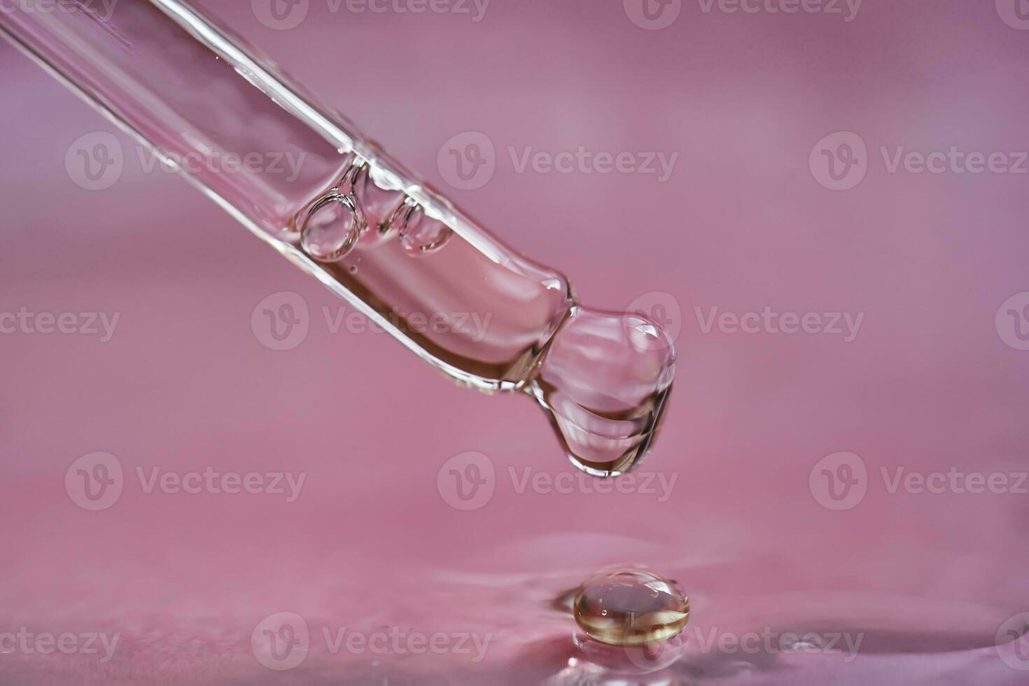 Dropper with serum or cosmetic oil on a pink background. photo