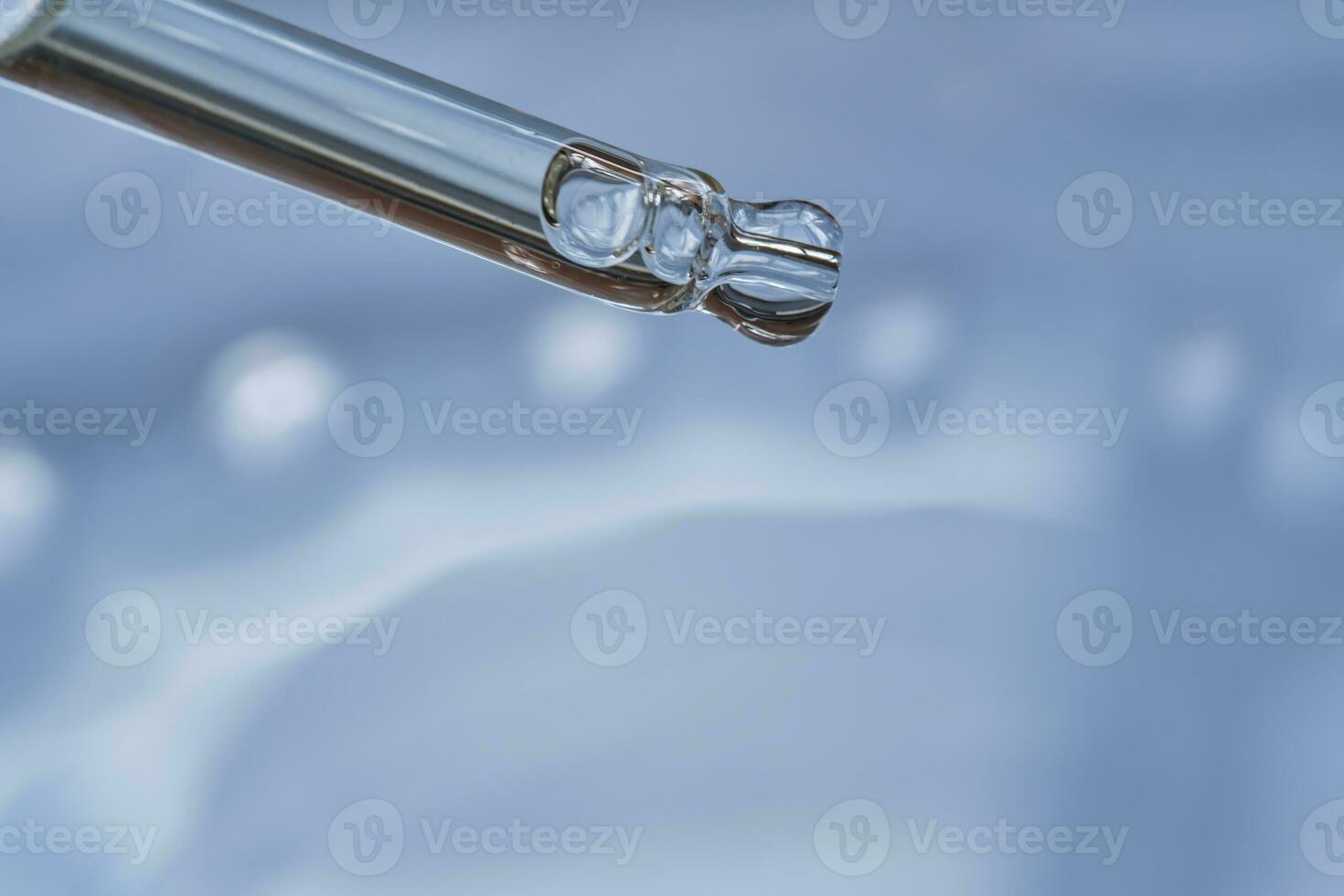 Dropper with serum or cosmetic oil on a blue background. photo