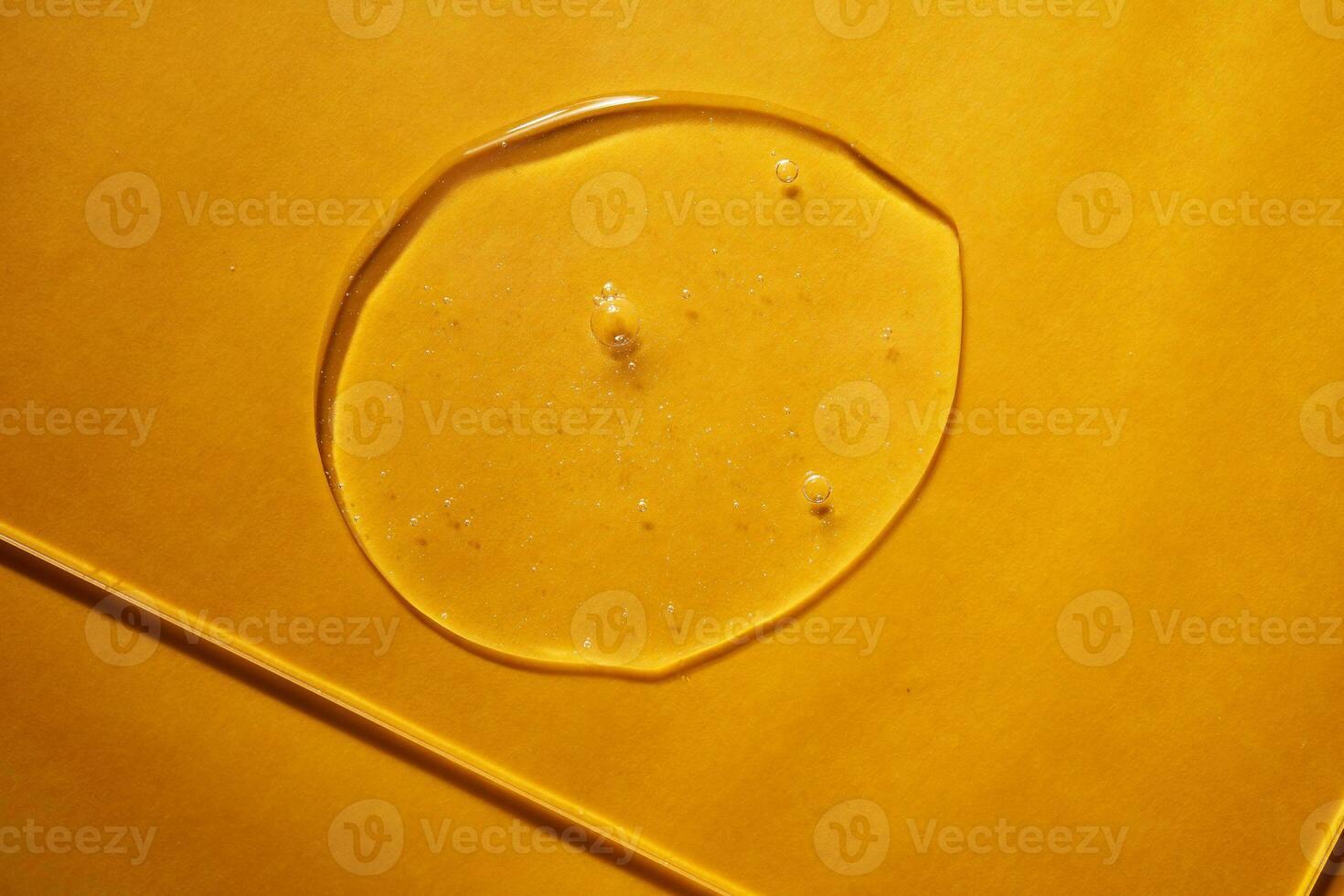 A drop of body gel or shampoo on a yellow saturated background. Texture. photo