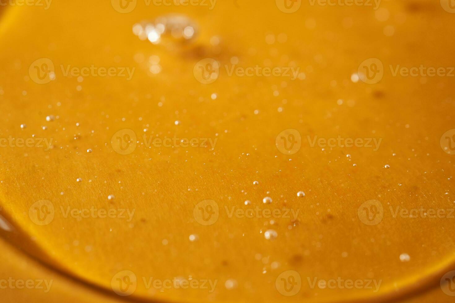 A drop of body gel or shampoo on a yellow saturated background. Texture. photo