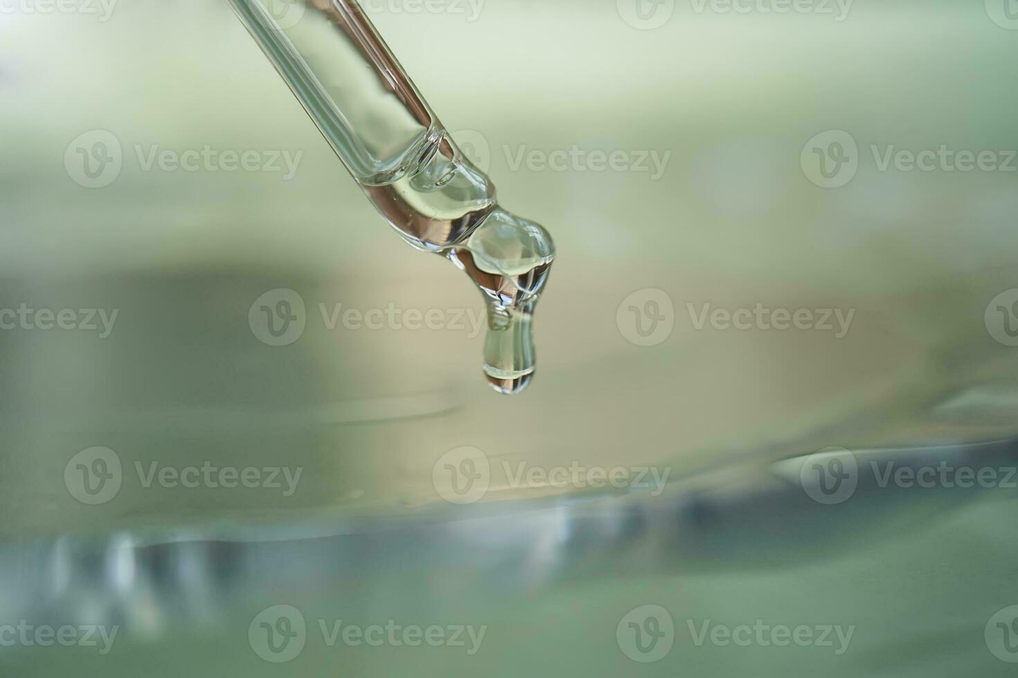 Dropper with serum or cosmetic oil on a green background. photo