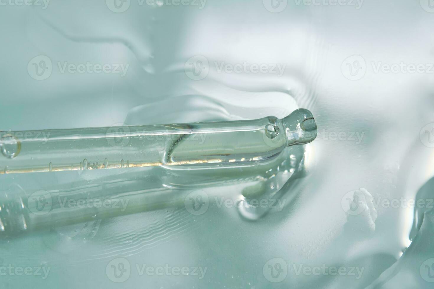 Dropper with serum or cosmetic oil on a green background. photo