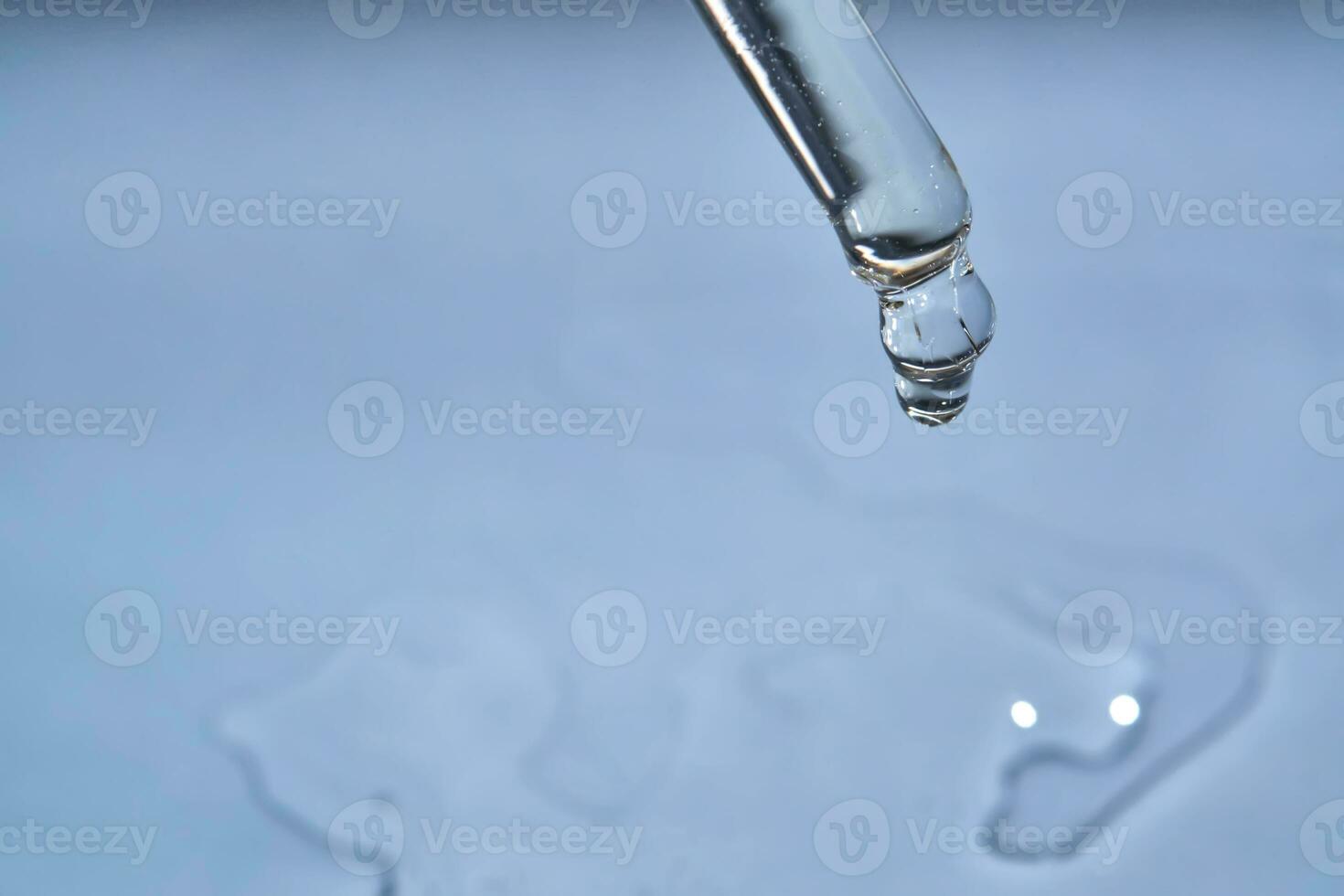 Dropper with serum or cosmetic oil on a blue background. photo