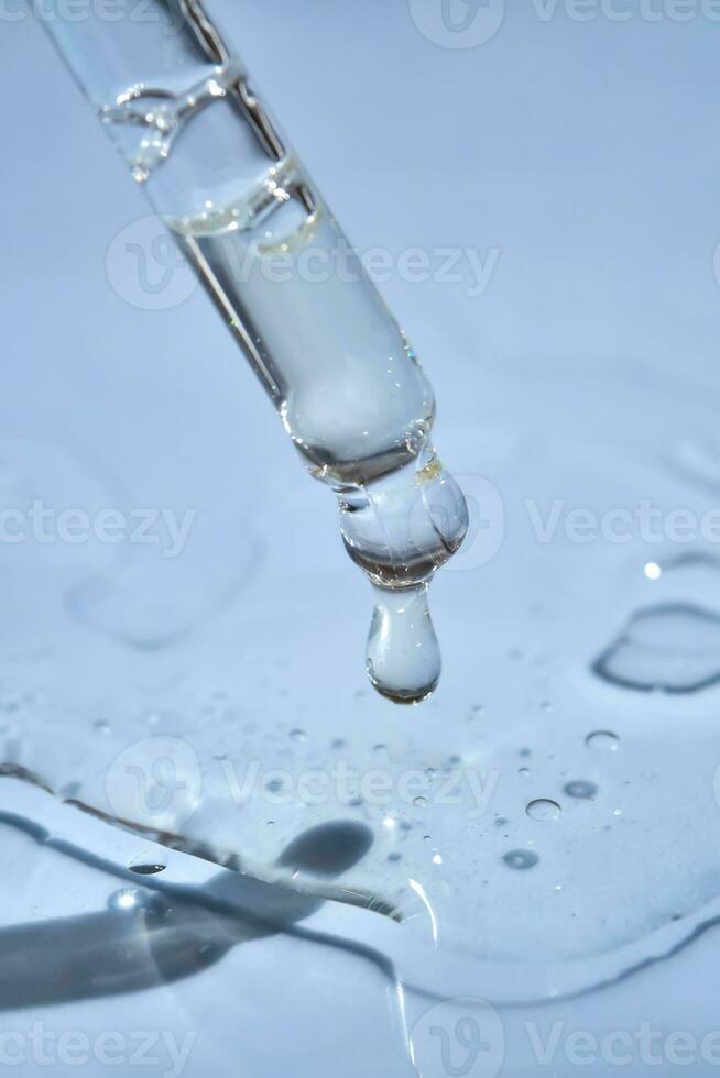 Dropper with serum or cosmetic oil on a blue background. photo