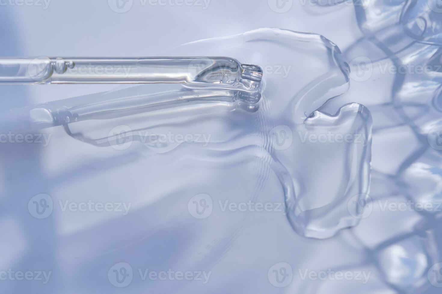 Dropper with serum or cosmetic oil on a blue background. photo