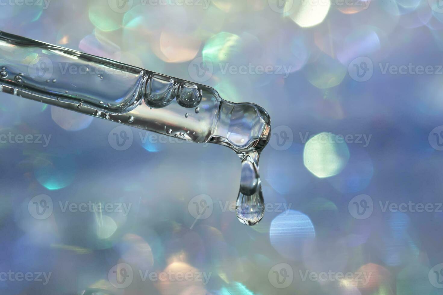 A pipette with a drop of serum in a Christmas theme . photo