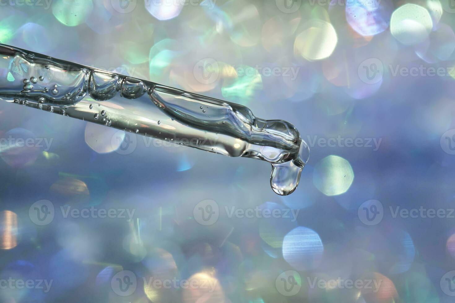 A pipette with a drop of serum in a Christmas theme . photo