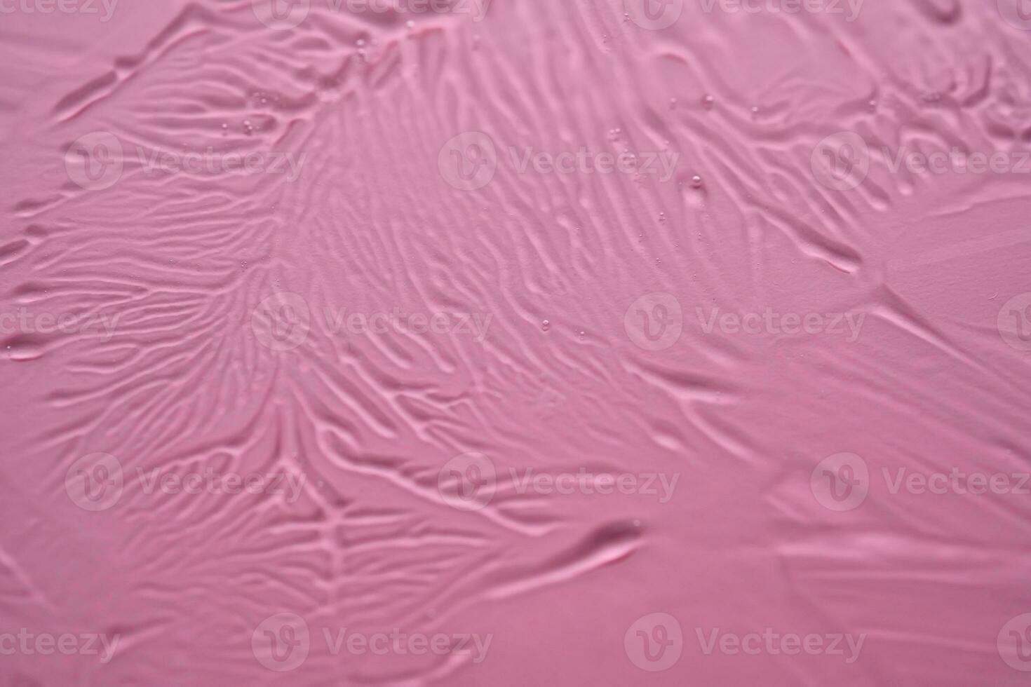 el textura de el cosmético gel en un rosado antecedentes. foto