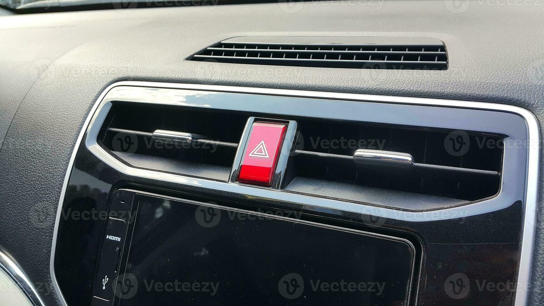 Car dasboard with AC vent, hazard light button and head unit display photo